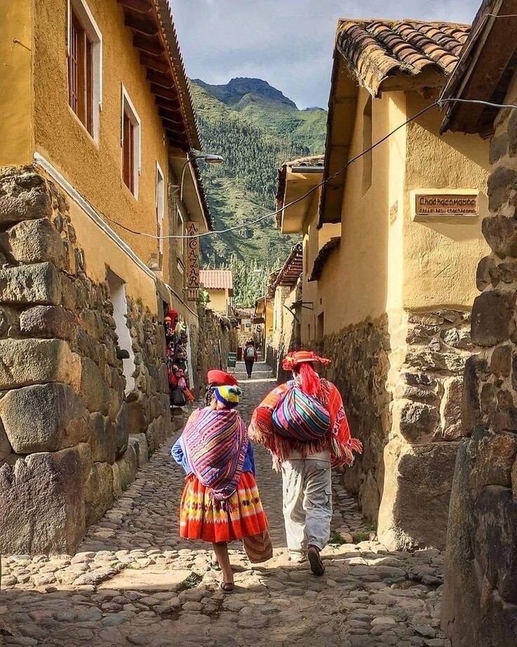 Pareja en vestimenta tradicional caminando por las calles de Ollantaytambo